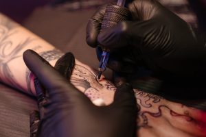 Close-up of a tattoo artist applying ink on a clients arm with precision.